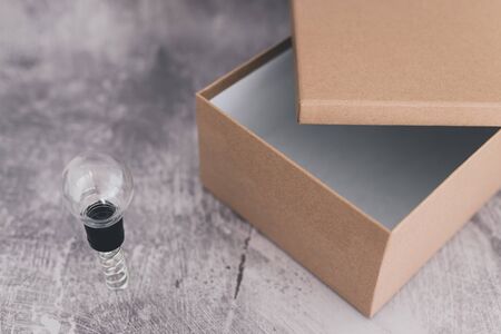 think outside the box concept: open box with miniature lightbulbs inside and a unique one outside on...