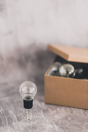 think outside the box concept: open box with miniature lightbulbs inside and a unique one outside on a springの写真素材