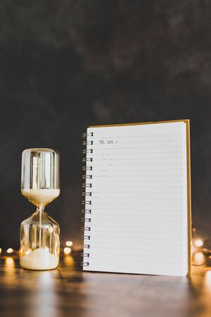 time to get things done conceptual image with hourglass and to do list notebook surrounded by fairy...