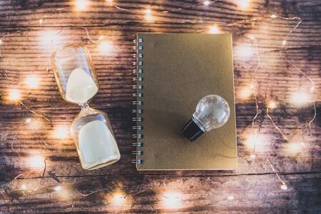 time to accomplish your goals conceptual image with hourglass, lightbulb and to do list notebook...