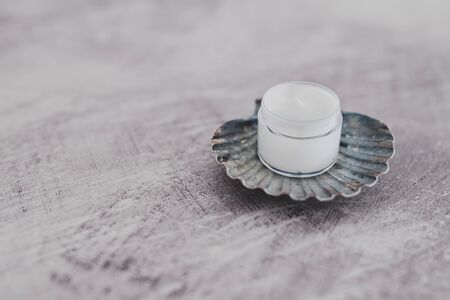 pot of moisturizer on top of sea shell, concept of beauty products with natural ingredients from the seaの写真素材