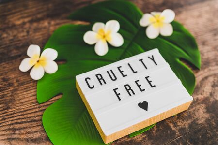 cruelty free message on lightbox with tropical settings on banana leaf and with plumeria flowers,...