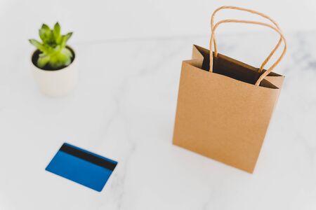 shopping bag on marble table top with payment card, shot at shallow depth of field with soft muted tonesの写真素材