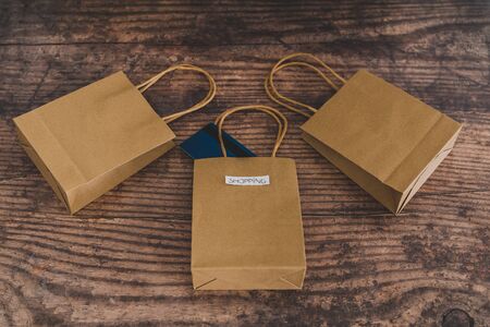 flatlay with shop bags with labels and paymen card popping out of one, concept of crazy or...