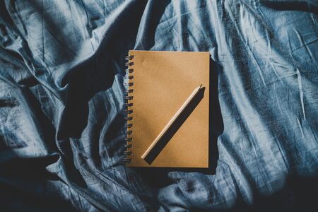 diary notebook on blue bedding; concept of journaling or brainstorming in the morningの写真素材