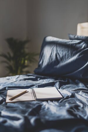 diary notebook on blue bedding; concept of journaling or brainstorming in the morningの写真素材