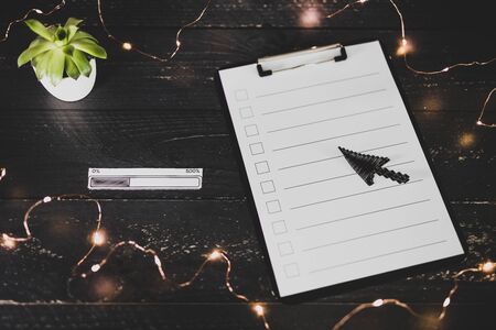 clipboard with blank list with cases to tick off on wooden desk with progress bar loading icon made of paper on top of it, concept of time management and scheduling tasksの写真素材