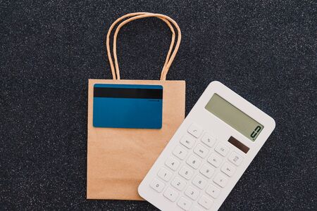 shopping bag with payment card and calculator, customer spending habits conceptの写真素材