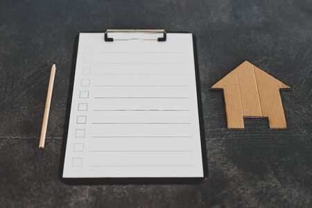 renovation or mortgage themed blank checklist with miniature house on clipboardの写真素材