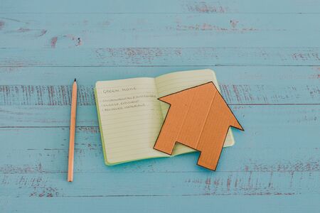 green home checklist, miniature house on notepad with sustainable elements for environmentally...