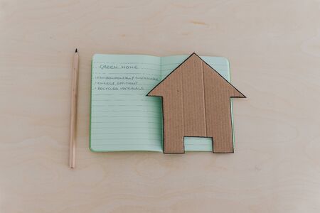 green home checklist, miniature house on notepad with sustainable elements for environmentally conscious propertyの写真素材