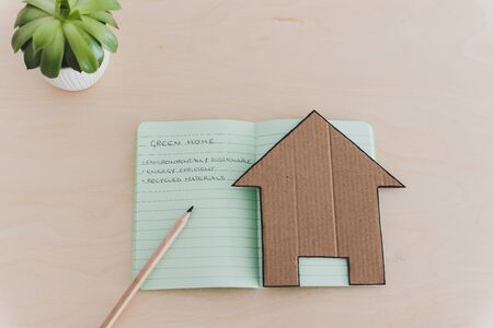 green home checklist, miniature house on notepad with sustainable elements for environmentally conscious propertyの写真素材