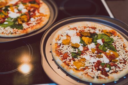frozen vegetarian pizzas on stove about to be cooked in the oven, easy meal conceptの写真素材