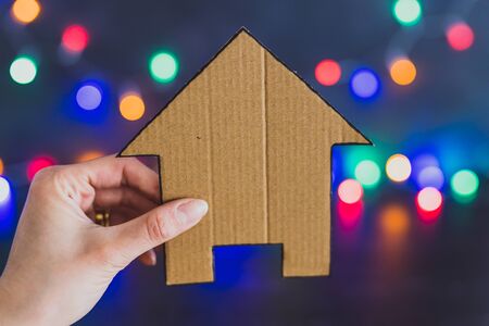 miniature house with festive multicolour string lights bokeh, concept of new house
