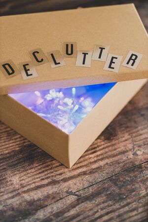 tidying up and sorting your possessions concept, declutter message on top of semi-open box to fill...