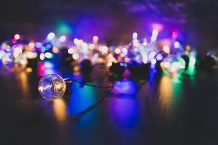 one unique lightbulb metaphor of good idea standing out from the crowd with group of others in the background with psychedelic lights, shot at shallow depth of fieldの写真素材