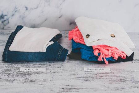 declutter and tidying up concept, fashion clothes folded and stacked into Keep and Declutter piles...