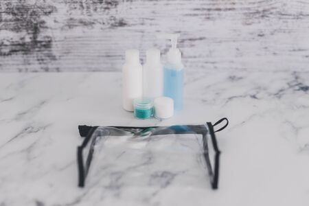 airport screening rules concept, small lotions for liquids and gel next to transparent bag for security check complianceの写真素材