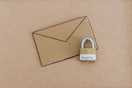 internet security and user privacy concept, email envelope miniature on desk with lock labelled security on itの写真素材