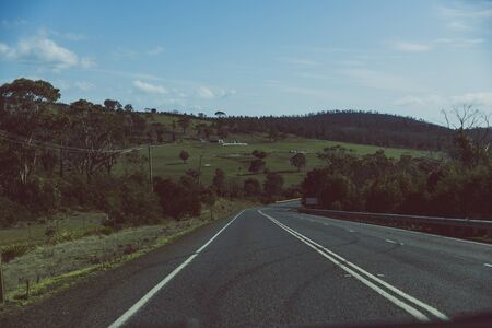 HOBART, AUSTRALIA - September 15th, 2019: countryside Tasmania with green fields and empty roads on a road trip from Hobart to Marion Bayのeditorial素材