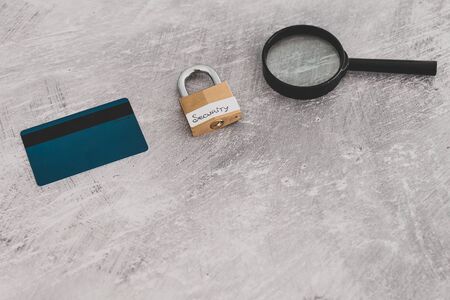 buyer protection and sensitive data online, credit card with security lock and magnifying glass on light concrete backgroundの写真素材