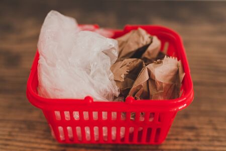 plastic pollution vs alternative materials, groceries shopping basket with both plastic and paper...