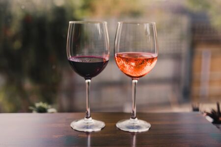 concept of partying and celebrating the moment, couple of glasses with orange cocktail and wine on...