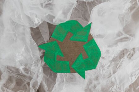 ecology and single-use plastic pollution concept, group of plastic bags with green recycle symbol