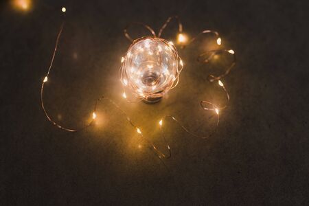 brilliant creativity and solutions, lightbulb with string lights around it shining in the dark