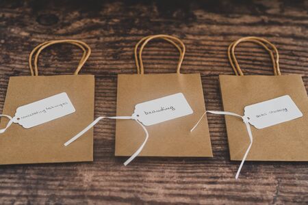 concept of shopping and sales strategy, group of price tags with Marketing Branding and Sales related text on them on top of shopping bagsの写真素材