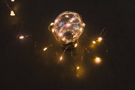 brilliant creativity and solutions, lightbulb with string lights around it shining in the dark