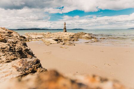 pebbles and rocks in zen inspiring stack on the shore in Australia with soft morning light and...