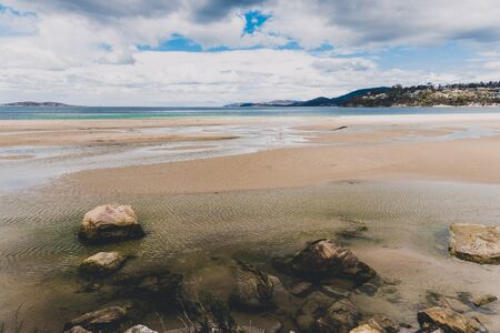 pristine Australian coastline and beach landscape with blue Pacific Ocean water and golden sand in...