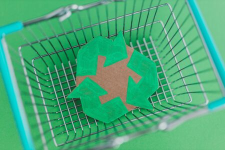 consumerism and environmental awareness, shopping basket with recycle symbol on it metaphor of eco-friendly purchasing habitsの写真素材