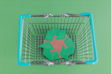 consumerism and environmental awareness, shopping basket with recycle symbol on it metaphor of eco-friendly purchasing habitsの写真素材