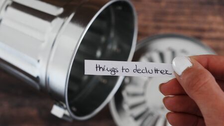 tidying up and decluttering your space concept, garbage bin and hand holding label saying Things to...