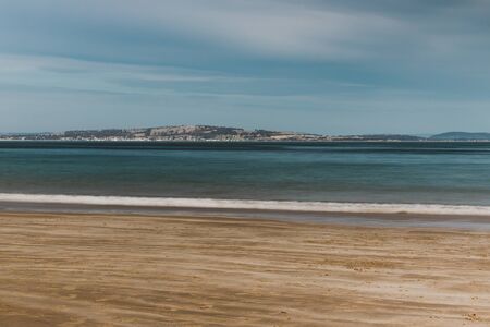 long exposure shot of pristine deserted Australian beach at dusk in Tasmania with moody tones and silky water effect and detail of coastlineの写真素材