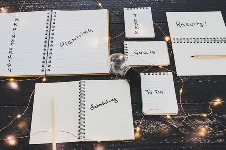 setting up for success conceptual still-life, business desk with variety of notebooks with step-by-step elements from planning to scheduling tasks and getting resultsの写真素材