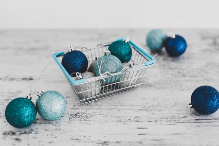 festive shopping and decorations conceptual still-life, Christmas baubles in shopping basket with...