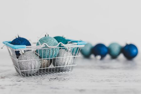 festive shopping and decorations conceptual still-life, Christmas baubles in shopping basket with blue and silvery tones shot at shallow depth of fieldの写真素材
