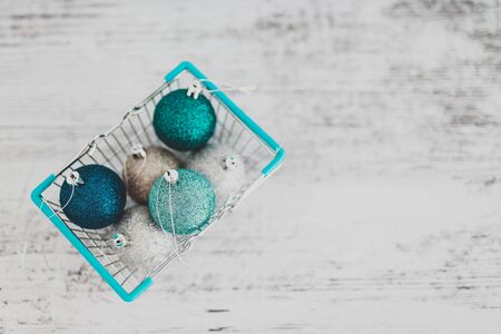 festive shopping and decorations conceptual still-life, Christmas baubles in shopping basket with blue and silvery tones shot at shallow depth of fieldの写真素材