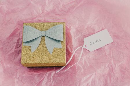 shopping and promotions conceptual still-life, Sales price tag next to gold and silver gift box on pink backgroundの写真素材