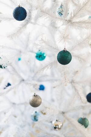 christmas tree with white frosted snow style and blue and silver toned baubles decoration, shot at shalow depth of fieldの写真素材