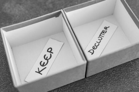decluttering and tidying up conceptual still-life, storage boxes with Keep and Declutter labels on...