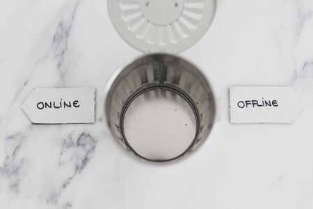 social media and living life online conceptual still-life, garbage bin with Online and Offline signsの写真素材