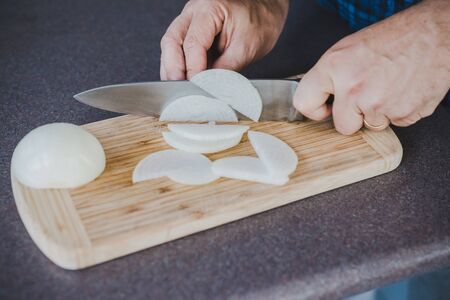 meal prepping concept, chef chopping onion on cutting boardの写真素材