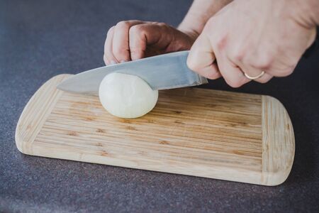 meal prepping concept, chef chopping onion on cutting boardの写真素材