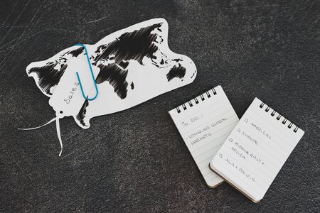 conquering global markets conceptual still-life, world map and text on to do list on business desk with continents to tick offの写真素材