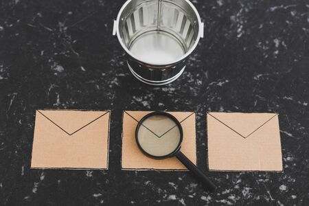 filtering or analyzing your inbox for spam conceptual still-life, magnifying glass on email envelope...