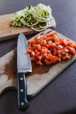 healthy food ingredients, diced tomatoes with knife on cutting board